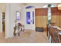 Charming foyer featuring a decorative glass door, elegant table, and neutral tile flooring at 151 Saddlebrook Way, Deland, FL 32724