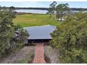 Aerial view of a home with a metal roof and brick pathway at 180 Robinson Ln, Seville, FL 32190