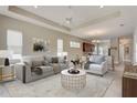 Bright and airy living room featuring a tray ceiling, neutral decor, and an open floor plan with lots of light at 430 Cypress Hills Way, Deland, FL 32724