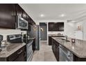 Modern kitchen featuring dark cabinetry, stainless steel appliances, and granite countertops at 635 Belgrove St, Debary, FL 32713
