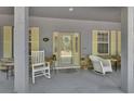 Inviting front porch with rocking chairs and decorative details offer charming curb appeal at 955 N Ridgewood Ave, Deland, FL 32720