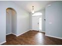 Inviting foyer with wood-look tile flooring, arched doorway, and a bright front door with sidelight at 189 Perfect Dr, Daytona Beach, FL 32124