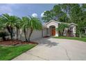 Inviting home featuring a two-car garage, landscaped yard, and elegant entryway with arched alcove at 189 Perfect Dr, Daytona Beach, FL 32124