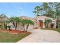 Tan house with palm trees, a two-car garage, and a manicured lawn at 189 Perfect Dr, Daytona Beach, FL 32124
