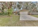 Tan single-story house with attached garage and mature landscaping at 2125 Queen Palm Dr, Edgewater, FL 32141