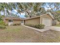 Tan single-story house with attached garage and mature landscaping at 2125 Queen Palm Dr, Edgewater, FL 32141