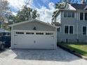 New two-car garage with white doors and paver driveway at 345 N Clara Ave, Deland, FL 32720