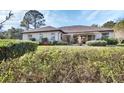 Landscaped backyard with lush greenery and a partially covered patio at 376 Hampton Hills Ct, Debary, FL 32713