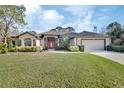 House exterior showcasing a manicured lawn and a two-car garage at 376 Hampton Hills Ct, Debary, FL 32713