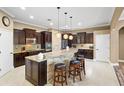 Spacious kitchen featuring granite countertops, dark wood cabinets, and a large island at 524 Quail Hill Dr, Debary, FL 32713