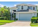 Two-story house with gray exterior, two-car garage, and lush landscaping at 5423 Swordfern Ct, Port Orange, FL 32128