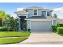 Two-story house with gray exterior, two-car garage, and well-maintained landscaping at 5423 Swordfern Ct, Port Orange, FL 32128