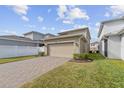 Attached garage with paver driveway and white fence at 5989 Painted Leaf Dr, Winter Garden, FL 34787