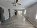 Bright living room featuring gray walls, wood-look floors, and ceiling fan at 610 Division St, Daytona Beach, FL 32114