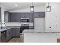 Stylish kitchen with gray cabinets, granite countertops, and modern stainless steel appliances at 1205 2Nd St, Orange City, FL 32763