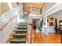 Elegant wooden staircase with a patterned runner and high ceilings at 163 Laurelwood Ln, Ormond Beach, FL 32174