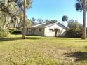 Back of the house showcasing a large grassy area and palm trees at 1848 Ridgewood St, Deland, FL 32720
