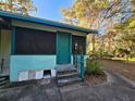 Quaint side porch with a green door and steps leading down at 1937 N Spring Garden Ave, Deland, FL 32720