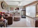Living room with tiled floor, brown couch, and treadmill at 2994 Annez Way, Debary, FL 32713