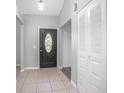 Inviting entryway with tile flooring, coat closet, and elegant front door at 3164 Chamberlain St, Deltona, FL 32738