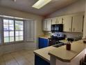 Cozy kitchen featuring blue cabinets and a breakfast bar at 3566 Red Pontiac Dr, Port Orange, FL 32129
