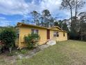 Single story home with a yellow exterior and a nicely landscaped yard at 3669 General Marshall Rd, Daytona Beach, FL 32124