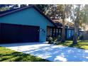 Newly painted teal home with dark brown garage doors and mature trees at 487 Dawnview Sq, Port Orange, FL 32127
