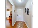 The hallway has a light fixture, white doors, and a beige patterned runner on wood floors at 55 Fairway Dr # 3D, Debary, FL 32713