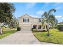 Two-story house with tan exterior, black shutters, and a two-car garage at 10025 Scottish Pines Ct, Orlando, FL 32832