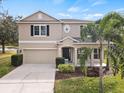 Two-story house with a two-car garage and palm trees in front at 10025 Scottish Pines Ct, Orlando, FL 32832