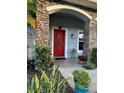 Inviting red front door with stone columns and landscaping at 12 Peruvian Ln, Ormond Beach, FL 32174