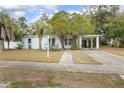 White ranch home with palm trees and a carport at 1579 Dunlap Dr, Deltona, FL 32725