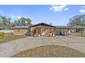 Tan single story house with wooden pillars and attached carport at 1701 N Stone St, Deland, FL 32720