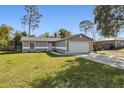 Front view of a house with a spacious yard and driveway at 1768 Santee Ave, Deltona, FL 32738