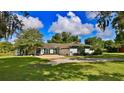 House exterior showcasing a light blue home with a white garage door and well-manicured lawn at 2530 E New York Ave, Deland, FL 32724