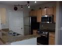 Galley kitchen with granite counters and stainless steel appliances at 2770 Coastal Bay Dr # 3-103, Orange City, FL 32763