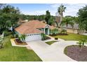 Inviting single-story home with lush front yard landscaping and a two-car garage, showcasing curb appeal at 39 Ormond Green Blvd, Ormond Beach, FL 32174