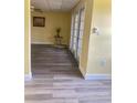 Bright living room with modern flooring and access to a private outdoor area through double doors at 701 Perkins St # 100, Leesburg, FL 34748