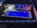 Nighttime aerial view of a rectangular pool with led lights and lounge chairs at 962 Compass Landing Dr, Orange City, FL 32763