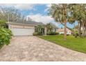 Tan paver driveway leading to a two-car garage at 123 Ponce Terrace Cir, Ponce Inlet, FL 32127