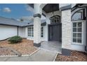 Inviting front entrance with stone columns and gray door at 130 Old Sunbeam Dr, South Daytona, FL 32119