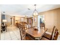 Open dining room with wood table and view to living room, bathed in warm natural light at 1413 La Paloma Cir, Winter Springs, FL 32708