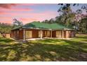 Brick home with green metal roof and covered patio at 1908 S Farm Rd, Deland, FL 32720