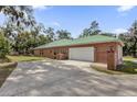 Attached brick garage with white door and driveway at 1908 S Farm Rd, Deland, FL 32720