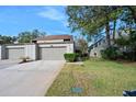 Exterior view of townhouse, showing garage and landscaping at 235 Pine Cone Trl, Ormond Beach, FL 32174