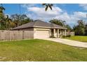 Tan house with a two-car garage and wooden fence at 304 Gardenia Ave, Debary, FL 32713
