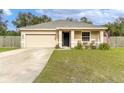 Tan house with a two-car garage and American flag at 304 Gardenia Ave, Debary, FL 32713