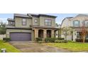 Two-story house with stone accents and a dark-colored garage door at 1106 Woods Landing Dr, Minneola, FL 34715