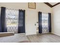 Living room with hardwood floors, gray sectional sofa, and two windows at 1240 W Voorhis Ave, Deland, FL 32720