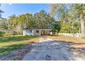 Front view of a white house with carport and fenced yard at 131 Wildwood Rd, Deland, FL 32720